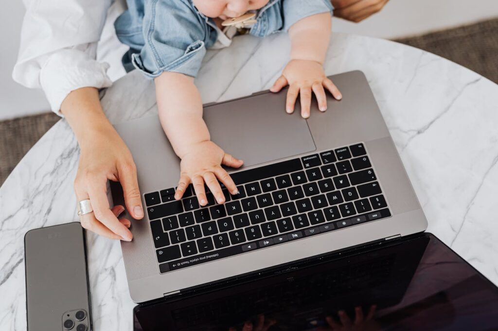 Top view of a parent and a child's hands on a laptop keyboard, symbolizing digital learning.