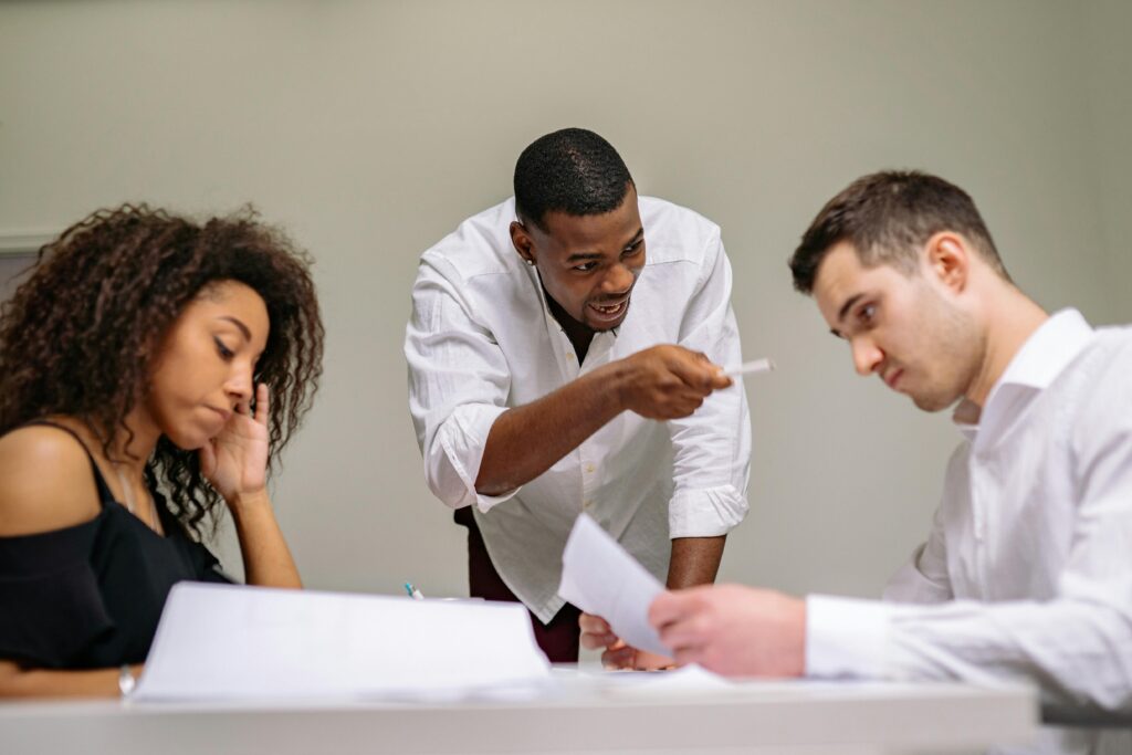 Dynamic office scene showing a tense discussion among diverse coworkers around a table.